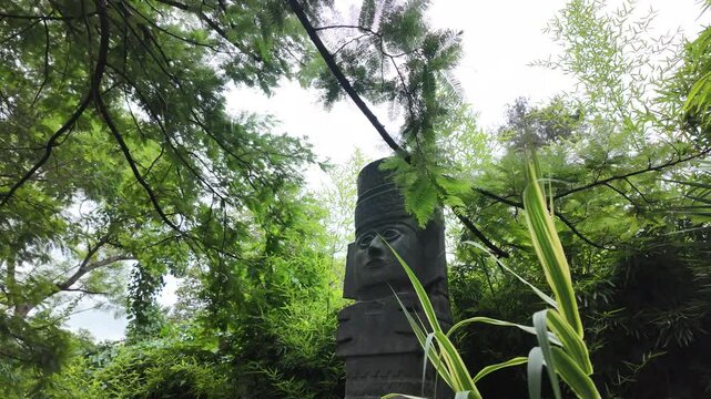Stone Totem Sculpture in Lush Green Garden