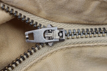 one gray open metal zip on brown fabric pants