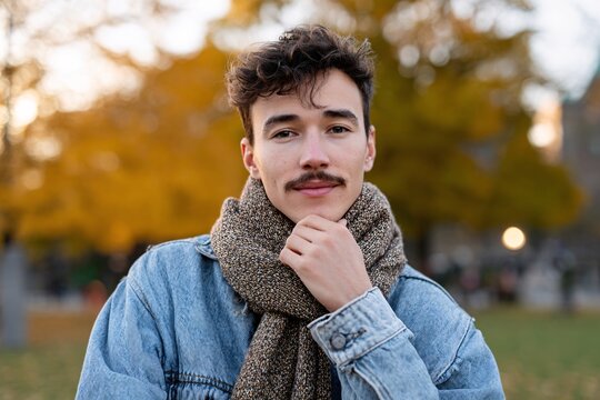 Young man promoting men's health with mustache in autumn park Generative AI