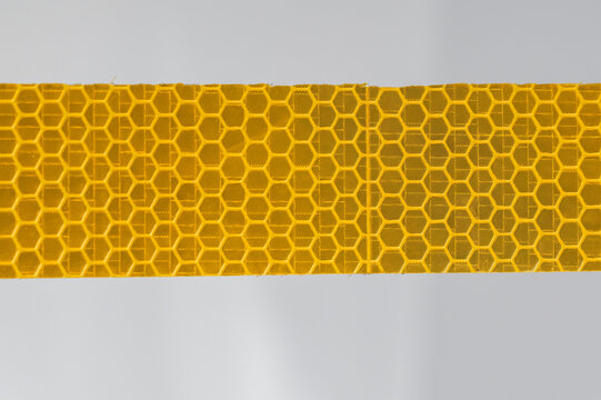 Yellow Reflective Safety Tape with Honeycomb Pattern &ndash; Close-Up of Retroreflective Material Texture, Industrial Safety Equipment, Road Sign and Vehicle Visibility Design Background