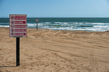 signage with various interdictions on using the beach near the ocean imposed by local authorities