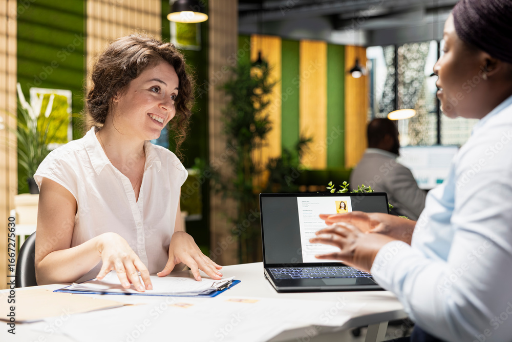Poster excited applicant reviews work terms on document and adds signature during a meeting within the hr d