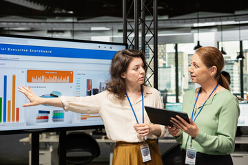 Women colleagues establishing a strategy and exchanging insights in multinational company, reviewing performance indicators to drive success and professional development. Powerful mindset.