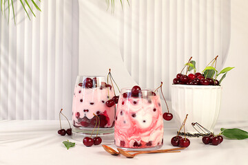 Fruit yogurt with cherries and fresh cow cream for healthy nutrition in a glass on an elegant...