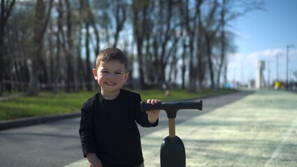 A Joyful Young Child Happily Riding a Colorful Scooter in the Park, Embracing Fun and Adventure
