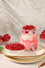 Modern still life with berries and drinks. Pomegranate yogurt with berries in a glass on an elegant...