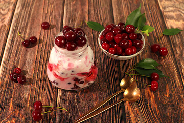 Cherry yogurt with berries in a glass on an elegant table, fruit salad, detox diet and natural nutrition concept, healthy breakfast with ingredients.advertisement of a healthy lifestyle