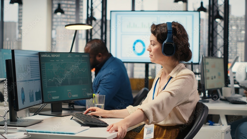Poster office administrator uses focus music on headset to solve tasks, monitoring performance metrics at t