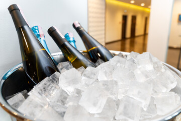 Elegant banquet setup with wine and champagne bottles chilling in a large ice bowl