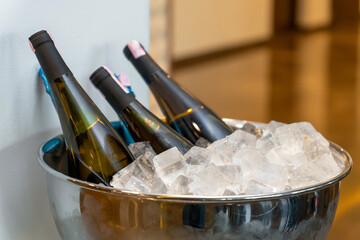 Elegant banquet setup with wine and champagne bottles chilling in a large ice bowl