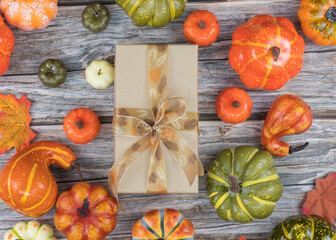 Rustic wooden table with yellow ribbon gift box and autumn leaves