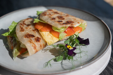 A flatbread stuffed with fish and cheese served in a cafe. Quesadilla.