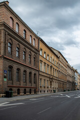 Fototapeta premium A view of Ulica Ivana Gundulica in Zagreb, Croatia. The image shows the perspective of an urban street with historic buildings and the wet roadway under an overcast sky.