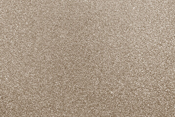 Gold glitter background, shiny sparkling champagne colored glitter particles creating textured...