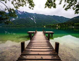 Fototapeta premium Tranquil lake pier with mountain backdrop