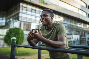 Young man sending a vocal message on his smart phone in the city