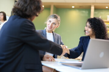 Diverse Team Working Together in Modern Co-Working Space. Casual meeting of smiling diverse business team analyzing financial data. Multiethnic business people working together in the office.