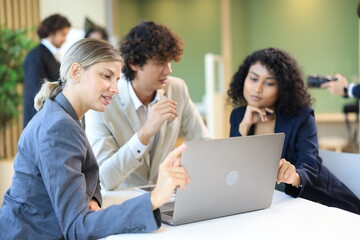 Diverse Team Working Together in Modern Co-Working Space. Casual meeting of smiling diverse business team analyzing financial data. Multiethnic business people working together in the office.