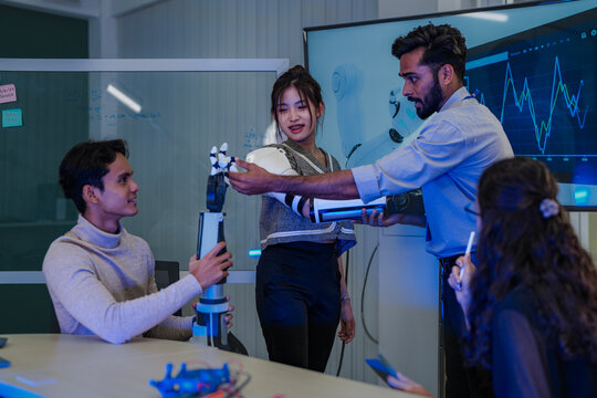 Bio-engineers run diagnostics on the neuromorphic circuitry of a prosthetic hand. A diverse team collaborates, troubleshooting the haptic sensors in their advanced robotics laboratory.