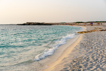 Crystal clear turquoise water gently washing the white quartz sand of Arutas beach in Sardinia, Italy