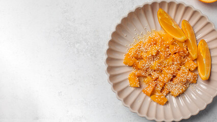 Healthy dessert with sliced pumpkin, honey and orange juice in a bowl. Pumpkin dish. Copy space