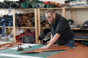 Caucasian bearded man working as a tanner in a workshop. 