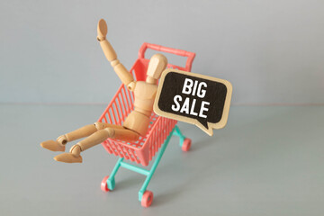 Shopping cart and wooden blocks with ''big sale'' written on white background.