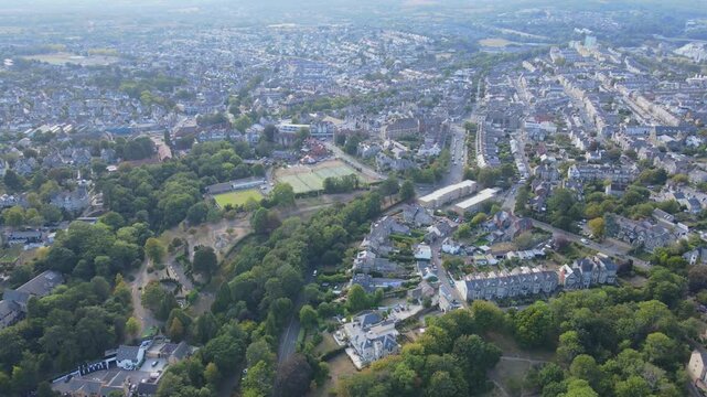 Aerial shot moving over Penarth town reverses to reveal coastline, cliffs, the beach and the Pier lots of cars can be seen driving below and the town stretches into the distance, Wales, UK, 4K, 60fps