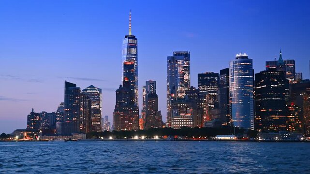 Beautiful luminous skyline of New York at dusk time. Low angle view on the stunning high-rises and skyscrapers from the riverscape.