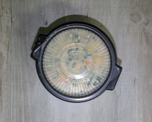 Top view of a round black plastic to go bowl with soup inside and clear lid on.