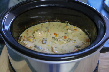 View of slow cooker chicken pot pie to be served with hot biscuits on the side. Crock pot chicken pot pie.