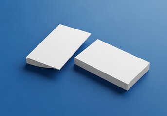 Two stacks of blank white business cards, showcasing a minimalist design, arranged on a vibrant blue surface