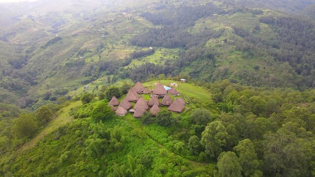 Aerial view of a complex of traditional houses in one of the villages in the Aileu Municipality in Timor Leste located in a hilly area. Still actively inhabited by locals and a tourist attraction.