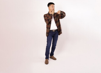 man checking time on watch while standing against a light background