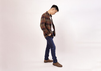 Naklejka premium a casual young man in a plaid shirt and jeans facing away