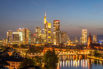 Obraz premium Illuminated Frankfurt Downtown Skyscrapers, Residential Buildings, Bridges and Main River at Night. Aerial View. Blue Hour. Hesse, Germany