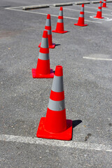 Orange traffic cones arranged on asphalt ground.