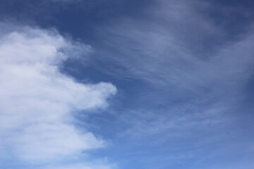 A clear blue sky with thin white clouds