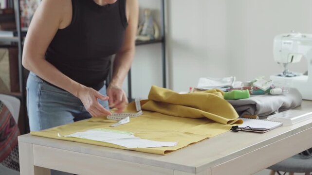Middle aged woman tailor precisely sewing clothing patterns in small business fashion studio independent entrepreneur business owner concept 4K footage.