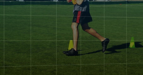 Legs wearing sportswear performing agility drill in sunlit grass field, with training cones