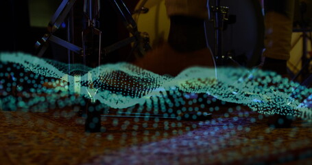 Displaying holographic wave rippling across rug in studio, cymbal tripod, bass pedal under shoes