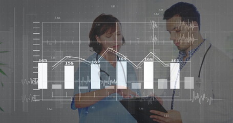 Nurse in scrubs and doctor in labcoat reviewing charts overlay in clinic with clipboard stethoscope