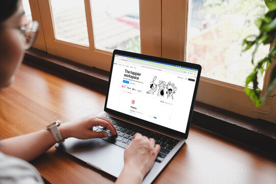 Bangkok, Thailand. August 29, 2025; A woman organizing her projects on the Notion productivity app on a laptop, working at a wooden desk by a window.