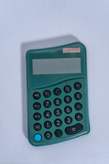 Green pocket calculator lying on white background