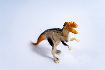 Dilophosaurus dinosaur toy roaring on white background