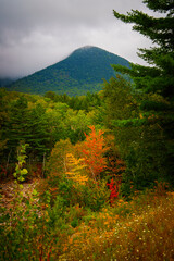 Autumn in New England, vibrant cloudy scene over Mt Hancock in the White Mountains near Loon Mountain along the East Branch Pemigewasset River in Lincoln, New Hampshire.