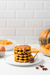 Homemade pumpkin waffles with honey and spices for cozy autumn breakfast