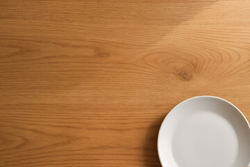 Wooden table with white plate close-up