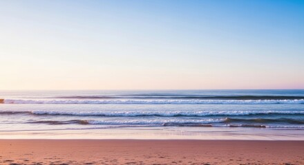 Obraz premium Serene Coastal Scene: Gentle Waves Rolling onto Sandy Beach at Sunset