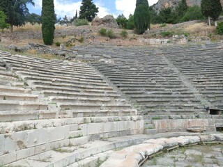 Weathered stone seats and stage of the ancient greek theater of Delphi, Greece